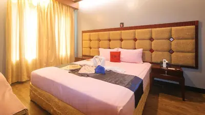 a hotel room with a bed with a large headboard at RedDoorz Premium at JjimJBang Hotel Spa in Manila