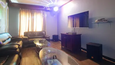a living room with a couch and a tv at RedDoorz Premium at JjimJBang Hotel Spa in Manila