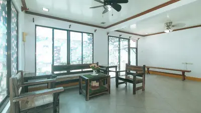 a living room with benches and a ceiling fan at RedDoorz at Joels Apartelle in Calaboso