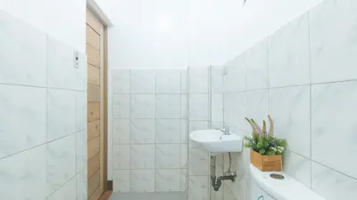 a white bathroom with a sink and a toilet at RedDoorz at Joels Apartelle in Calaboso