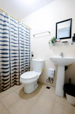 a bathroom with a toilet and a sink at Premium 1BR unit at The Avant in Manila