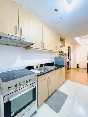 a kitchen with a stove and a sink at Premium 1BR unit at The Avant in Manila