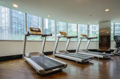 a gym with three treadmills in front of windows at Premium 1BR unit at The Avant in Manila