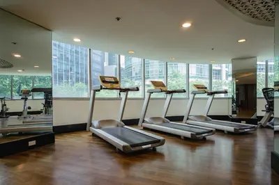 a gym with several treadmills in a room with windows at Premium 1BR unit at The Avant in Manila