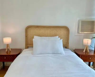 a white bed with two nightstands and two lamps at Charming 3-BR Condo in BGC in Manila