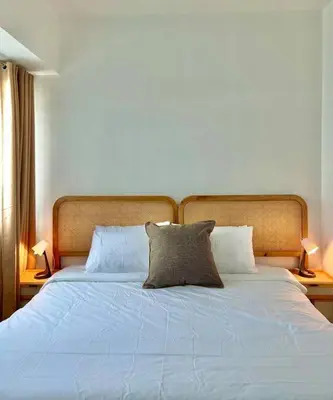 a bed with blue sheets and two pillows on it at Charming 3-BR Condo in BGC in Manila