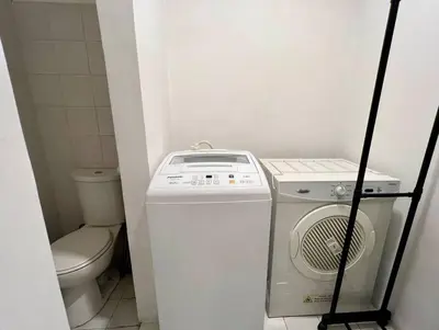 a small bathroom with a washing machine and a toilet at Charming 3-BR Condo in BGC in Manila
