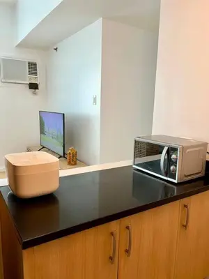 a kitchen with a microwave and a toaster oven on a counter at Charming 3-BR Condo in BGC in Manila