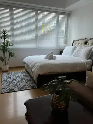 a bedroom with a bed and a table with a plant at Contemporary Studio at Avant BGC in Manila