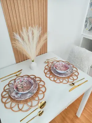 a white table with two plates and gold spoons at Paradise Realm Condotel in Manila
