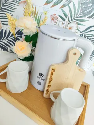 a cutting board with a mixer and cups on it at Paradise Realm Condotel in Manila