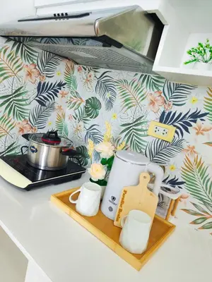 a kitchen counter top with a tea kettle and cups at Paradise Realm Condotel in Manila