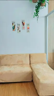 a couch in a living room with posters on the wall at Paradise Realm Condotel in Manila