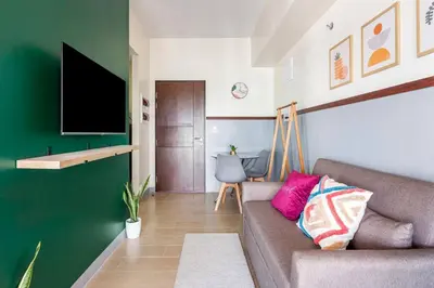 a living room with a couch and a flat screen tv at Executive 1 Bedroom with Pool Sauna Gym and More in Manila