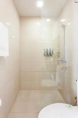 a bathroom with a shower with a toilet and a sink at Executive 1 Bedroom with Pool Sauna Gym and More in Manila
