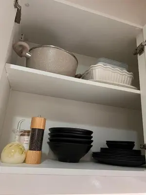 a white cabinet with dishes and a bowl and plates at Executive 1 Bedroom with Pool Sauna Gym and More in Manila