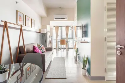 a living room with a couch and a table at Executive 1 Bedroom with Pool Sauna Gym and More in Manila