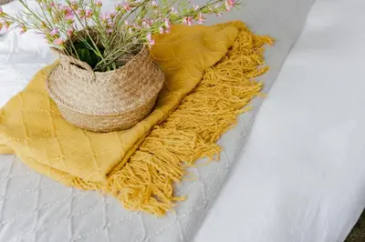 a vase of flowers sitting on a yellow blanket at The Oasis 1 BR with Pool Sauna Gym and More in Manila