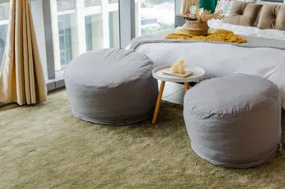 a bedroom with two ottomans and a bed with a table at The Oasis 1 BR with Pool Sauna Gym and More in Manila