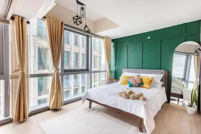a bedroom with green walls and a bed with teddy bears on it at The Sweet Escape 1 BR w Pool, Sauna, Gym and More in Manila