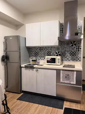 a kitchen with a refrigerator and a microwave at AZURE Urban Resort Residences Paranaque City in Manila