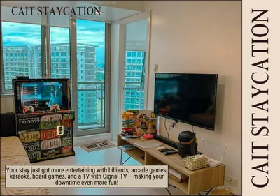 a living room with a tv and a large window at Azure Parañaque - 2br Beach View 18th Floor in Manila