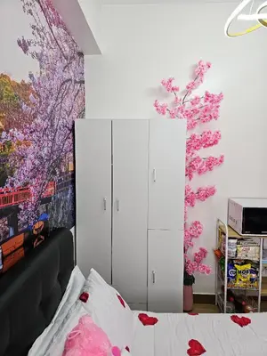 a bedroom with a white cabinet and pink flowers on the wall at Lakwatsero Caviteño Suites in Trece Martires