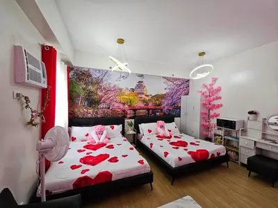 a bedroom with two beds with red roses on them at Lakwatsero Caviteño Suites in Trece Martires