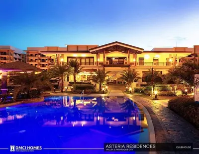 a large building with a swimming pool in front of it at Eves Urban Haven in Manila