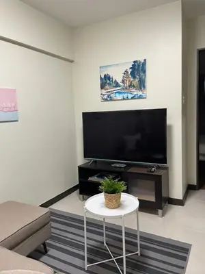 a living room with a large flat screen tv at Eves Urban Haven in Manila