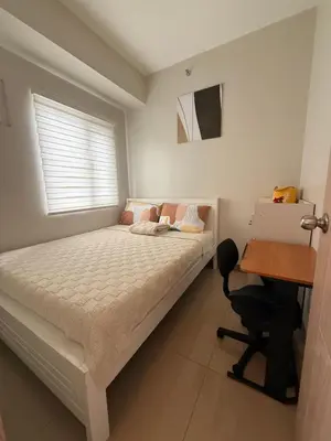 a bedroom with a bed and a desk and a desk at Urban Oasis 2BR Condo with Multiple Pools at SMDC Charm Residences in Manila
