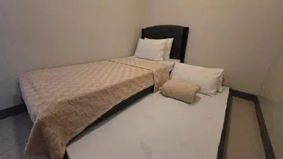 two twin beds in a corner of a room at Urban Oasis 2BR Condo with Multiple Pools at SMDC Charm Residences in Manila