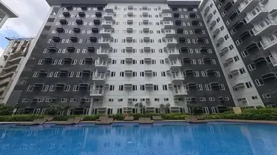 a large building with a swimming pool in front of it at Urban Oasis 2BR Condo with Multiple Pools at SMDC Charm Residences in Manila