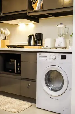 a kitchen with a washing machine under a counter at Le Martell 1BR BGC Condo Unit - Infinity Pool & Gym Access with 360 City View in Manila