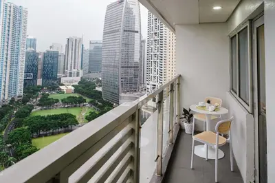 a balcony with a table and a view of a city at Le Martell 1BR BGC Condo Unit - Infinity Pool & Gym Access with 360 City View in Manila