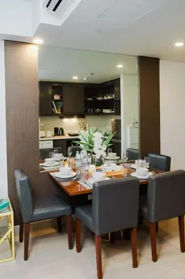 a dining room with a wooden table and chairs at Le Martell 1BR BGC Condo Unit - Infinity Pool & Gym Access with 360 City View in Manila