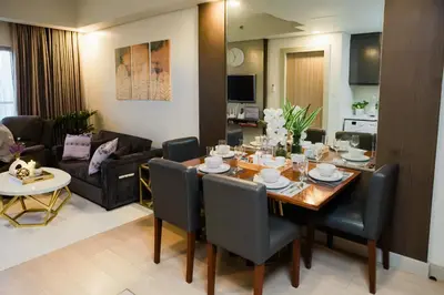a dining room and living room with a table and chairs at Le Martell 1BR BGC Condo Unit - Infinity Pool & Gym Access with 360 City View in Manila