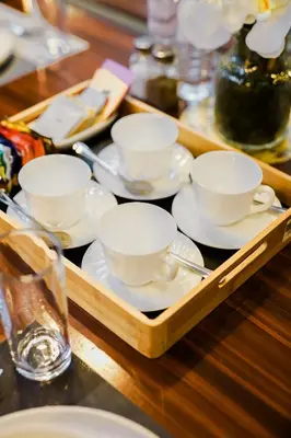 a tray of tea cups and saucers on a table at Le Martell 1BR BGC Condo Unit - Infinity Pool & Gym Access with 360 City View in Manila