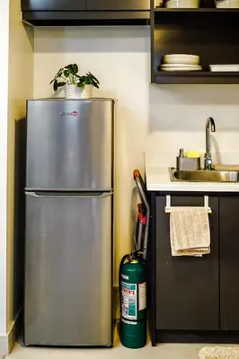 a stainless steel refrigerator in a kitchen with a sink at Le Martell 1BR BGC Condo Unit - Infinity Pool & Gym Access with 360 City View in Manila