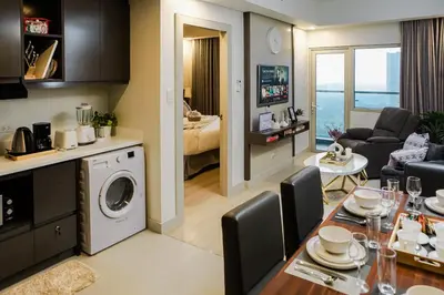 a kitchen and living room with a table and a living room at Le Martell 1BR BGC Condo Unit - Infinity Pool & Gym Access with 360 City View in Manila