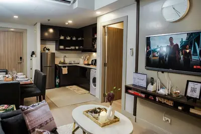 a living room with a television on a wall at Le Martell 1BR BGC Condo Unit - Infinity Pool & Gym Access with 360 City View in Manila