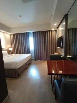 a large hotel room with a bed and a table at GBA Condotel at Bonifacio Civic Center Tower in Manila