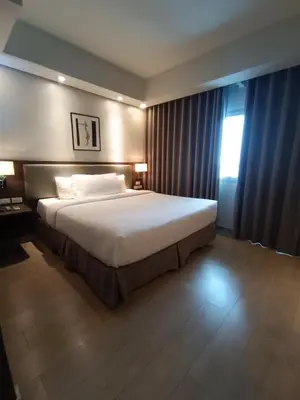 a bedroom with a large bed and a window at GBA Condotel at Bonifacio Civic Center Tower in Manila