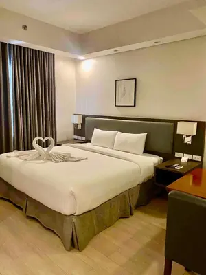 a bedroom with a large bed in a hotel room at GBA Condotel at Bonifacio Civic Center Tower in Manila