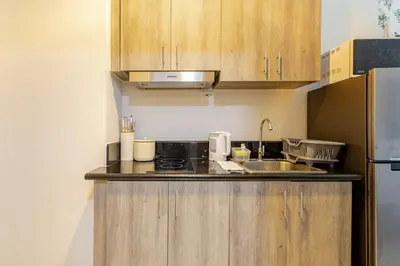 a small kitchen with a sink and a refrigerator at The Prestige Bayview with Balcony in Manila