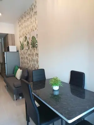 a dining room table with chairs and a couch at The Prestige Bayview with Balcony in Manila