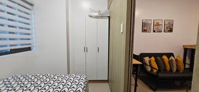 a bedroom with a white cabinet and a chair at Q Workcation WFH Staycation in Manila