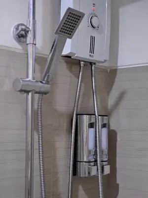 a water heater is hanging from a wall in a bathroom at Q Workcation WFH Staycation in Manila