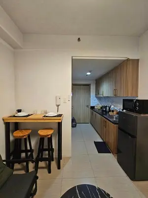 a kitchen with a counter and a table with stools at Q Workcation WFH Staycation in Manila