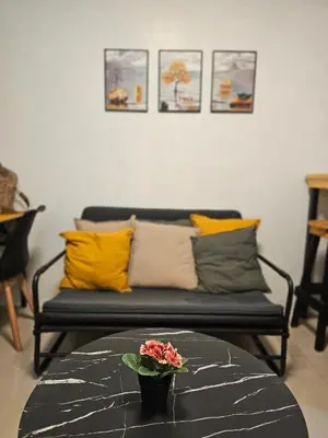 a living room with a couch with pillows and a table at Q Workcation WFH Staycation in Manila